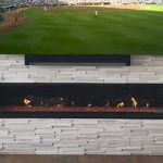 a fireplace below a tv with a baseball game on
