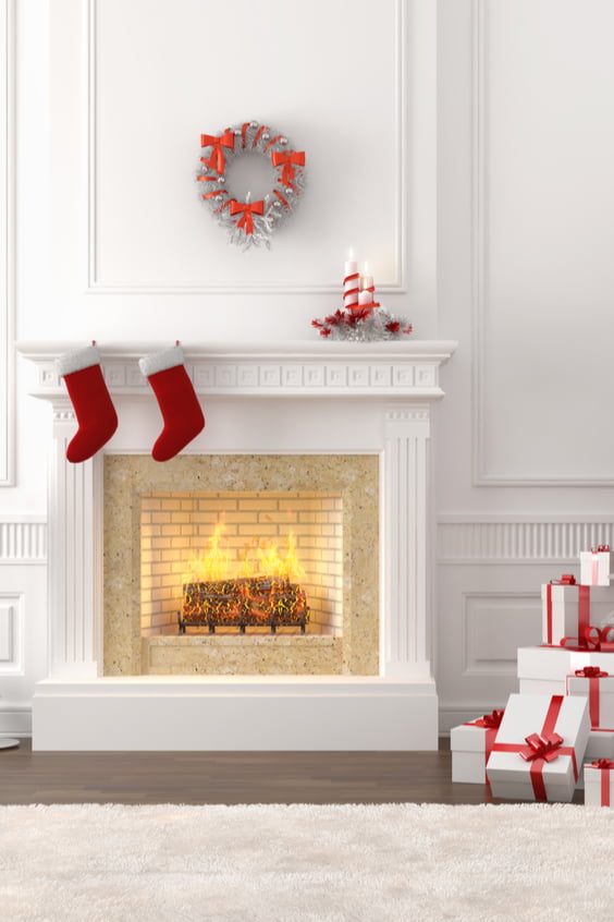 A fireplace with stockings hanging from it and presents nearby