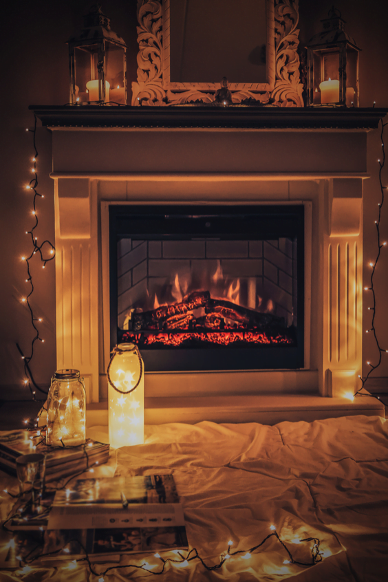 A fireplace with Christmas lights around it