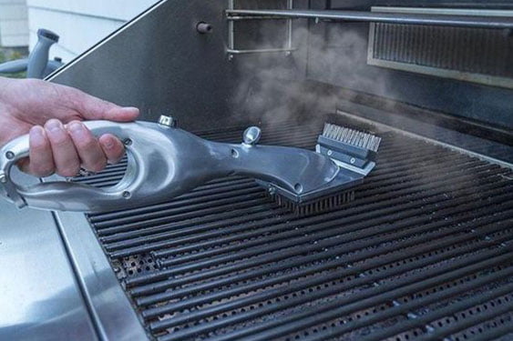 hand cleaning a grill