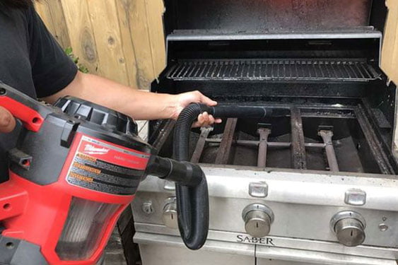 hand vacuuming a grill